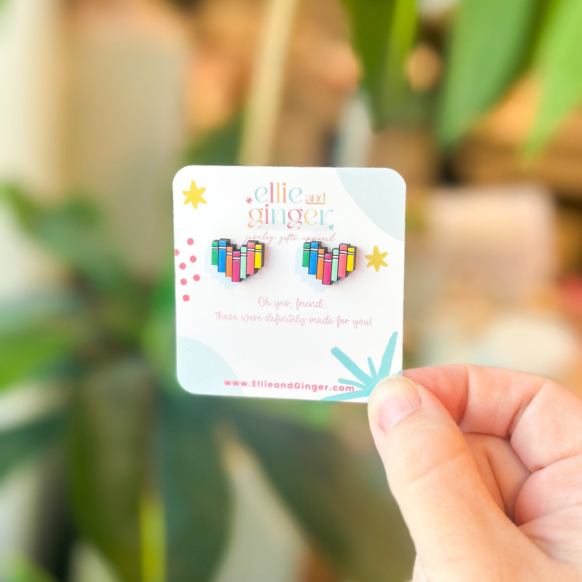 Handpainted wood stud earrings in the shape of a heart that looks like a row of books
